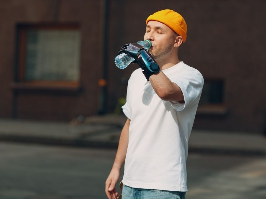 Man with prosthetic hand drinking bottled water