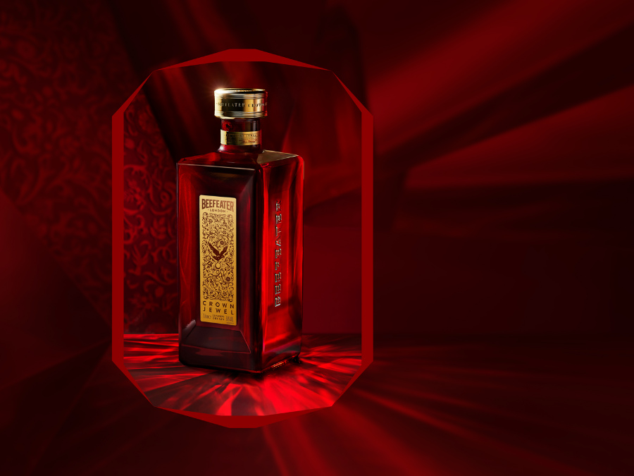 A bottle of Beefeater Crown Jewel Gin, on a dark red background. The bottle appears as though inside a jewel.