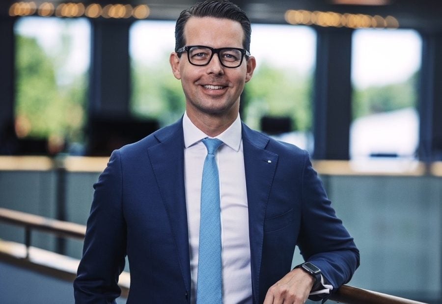 Portrait of Jacob Aarup-Andersen, Carlsberg Group CEO smiling against a handrail