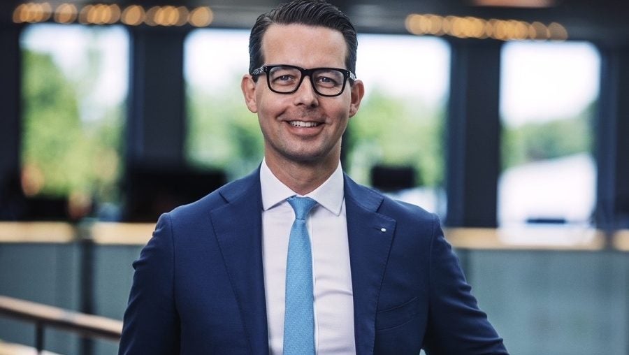 Portrait of Jacob Aarup-Andersen, Carlsberg Group CEO smiling against a handrail