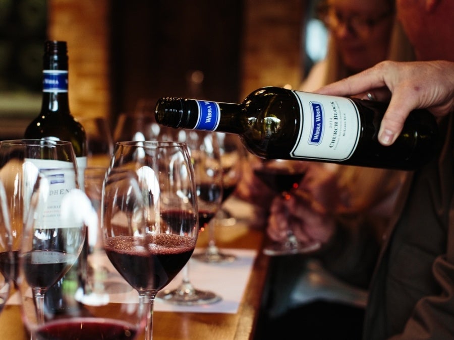 A hand pours a glass of Wirra Wirra Church Block Cabernet Sauvignon at a tasting