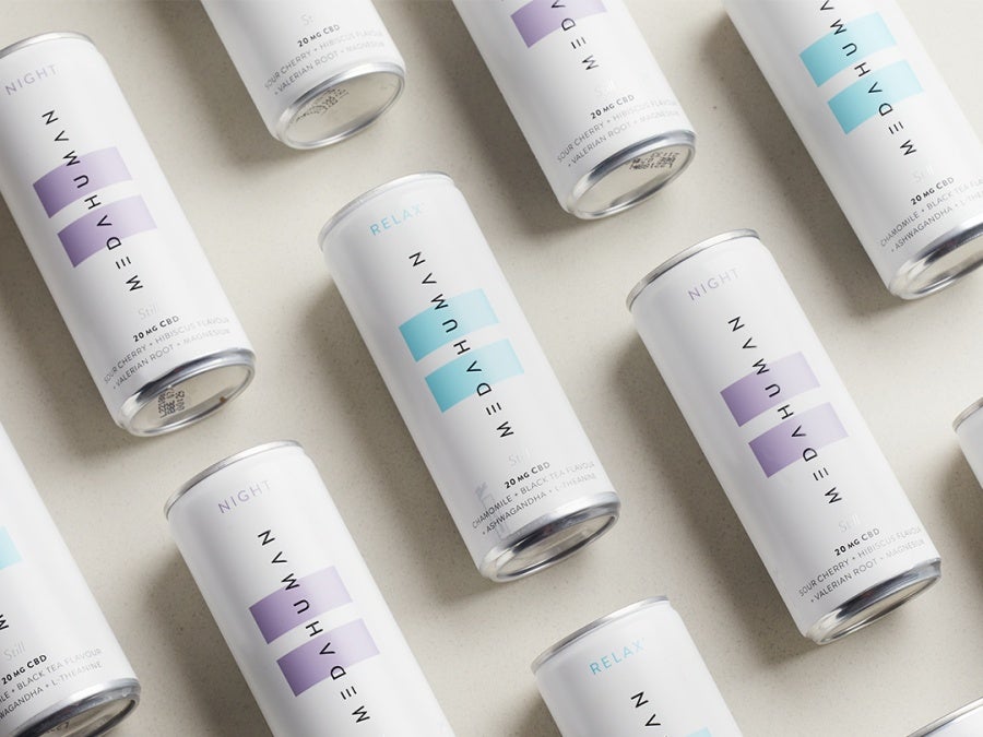 Cans of Medahuman drinkslaid flat spread out against a cream background