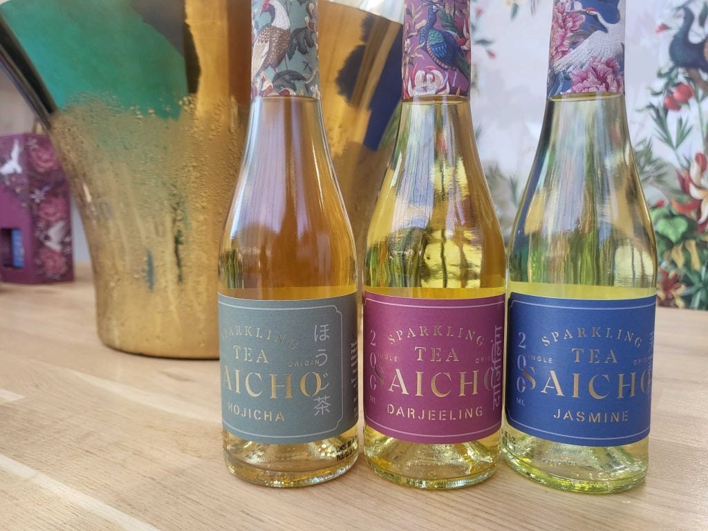 Three Saicho sparkling tea mini bottles up close on the label, in a row with an ice bucket in the background