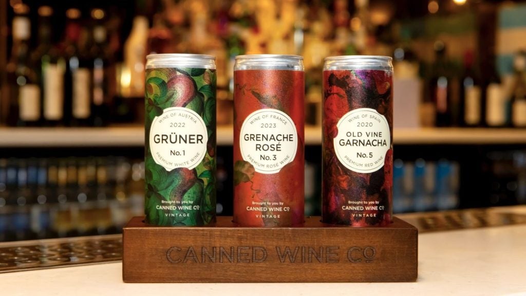 multicoloured canned wines in wooden box on bar.
