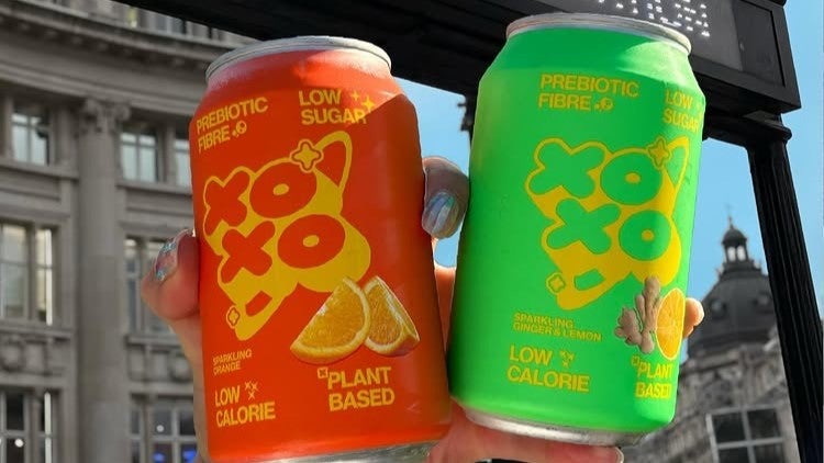 neon orange and green cans of prebiotic soda at Oxford Circus station, London, United Kingdom.