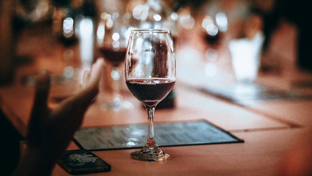 A glass of wine on a table in a bar