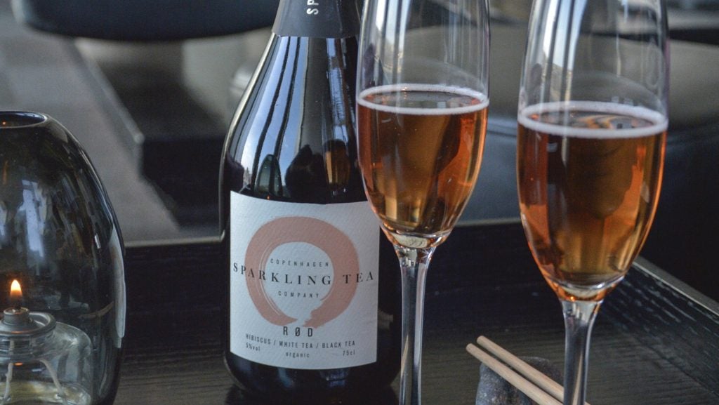 A bottle of Copenhagen Sparkling Tea with two glasses