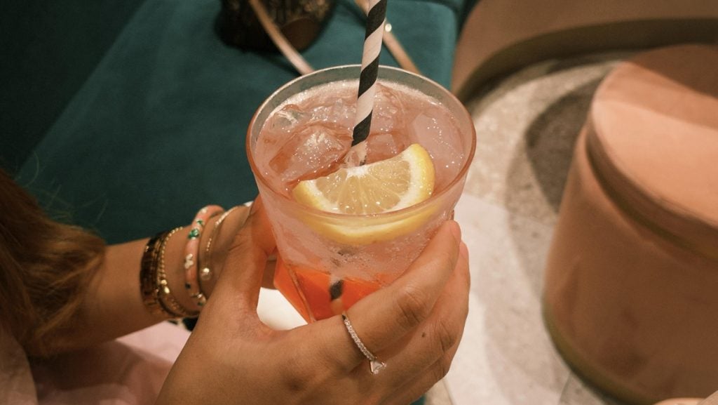 A woman holds a Paloma cocktail
