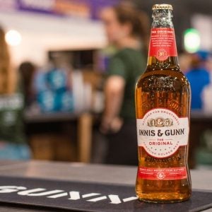 Innis & Gunn bottle of beer on black and white beer mat in bar setting.