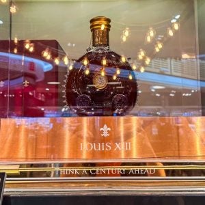 Copenhagen, Denmark - September 02, 2025: Louis XIII de Remy Martin bottle showcased in illuminated transparent box inside liquor store highlighting luxury and exclusivity